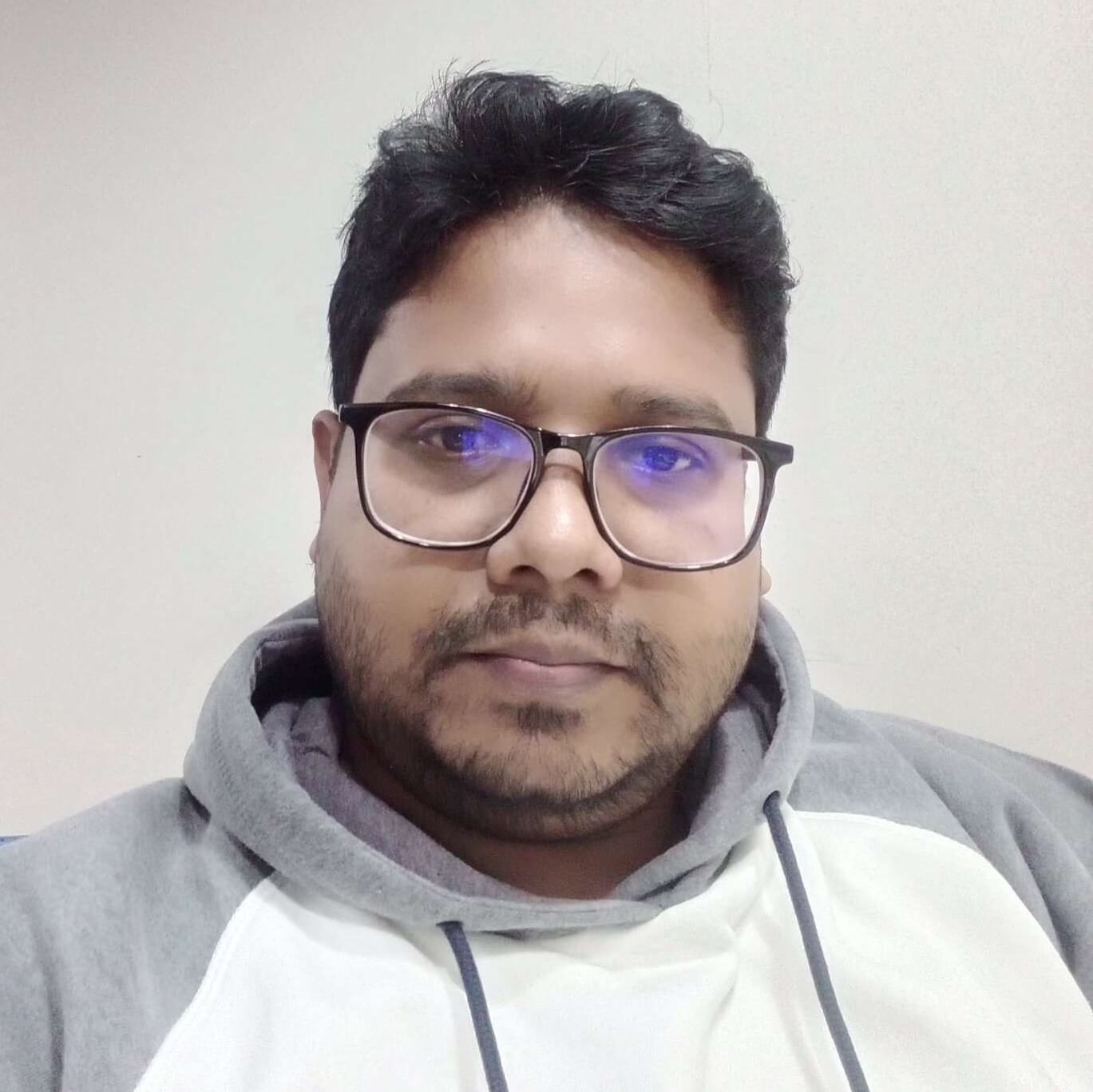 A man in a blue shirt stands with arms crossed, representing SEO Specialist Kamal Husen from Rankupper.