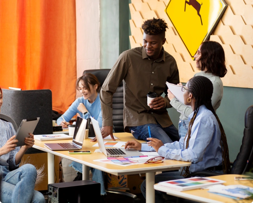 A group of professionals working at a table with laptops in a modern Rankupper office environment. Featured on the Rankupper.